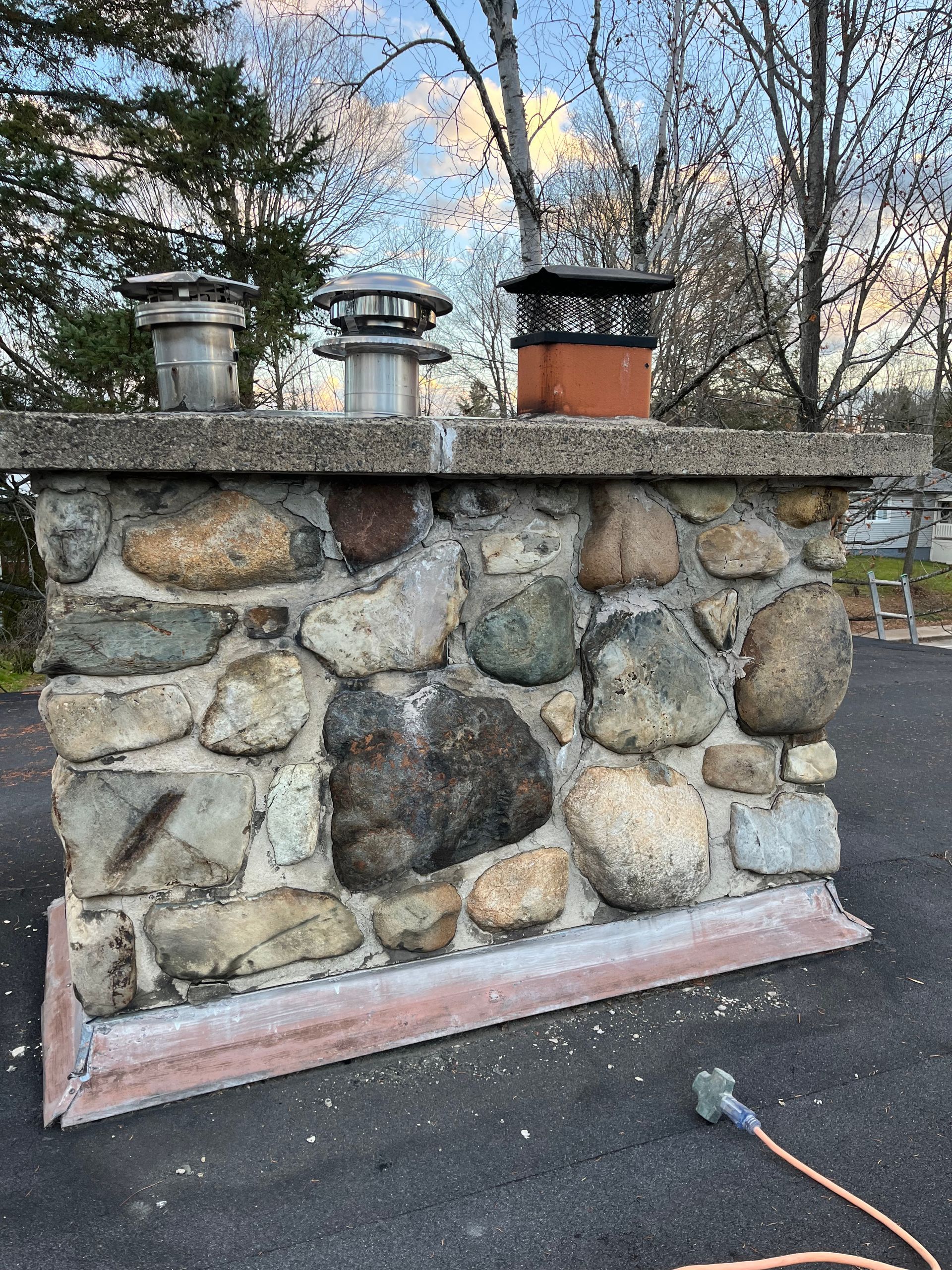 Un mur de pierre surmonté d'une cheminée.