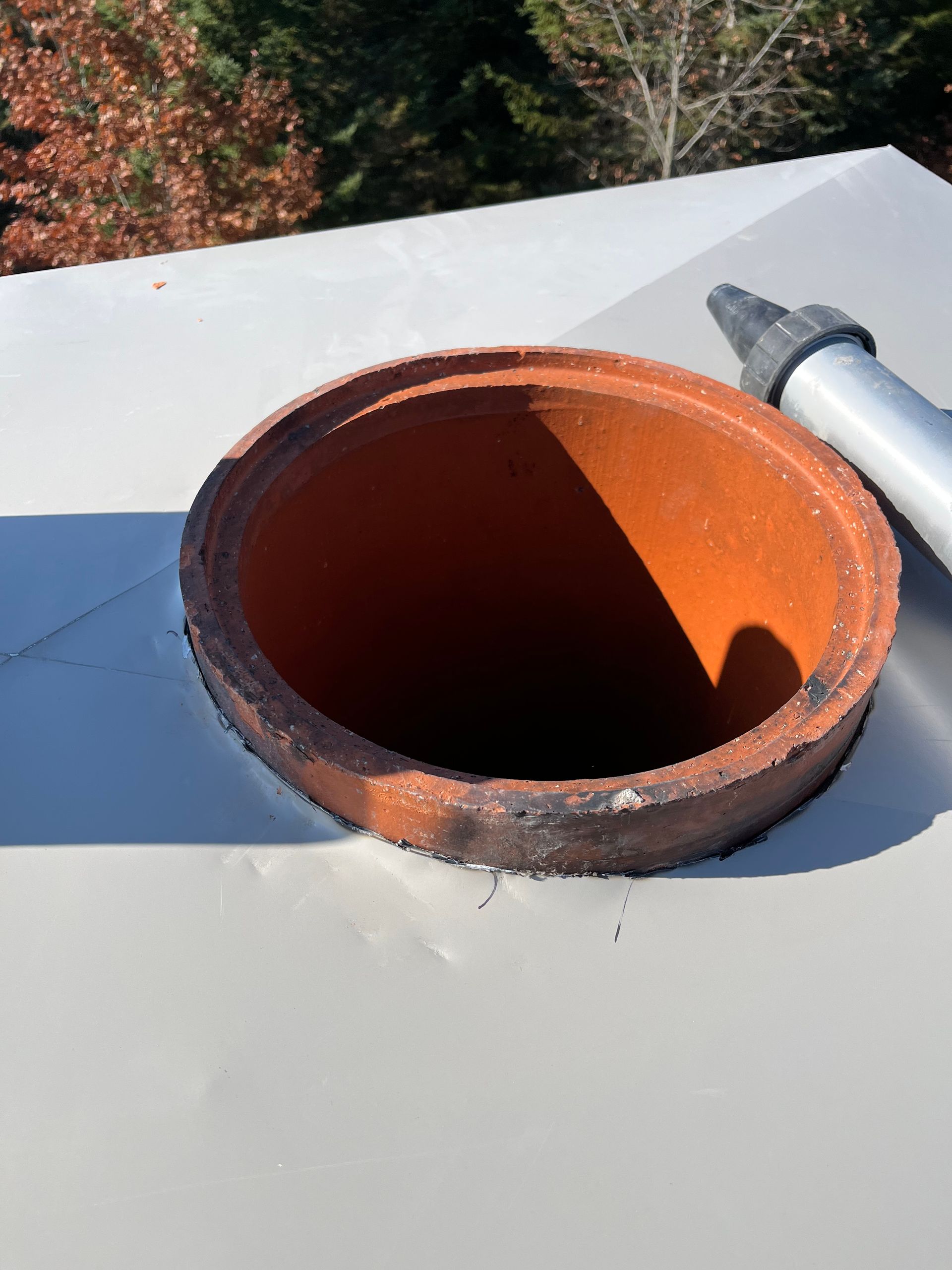 Un pot en argile est posé sur une surface blanche
