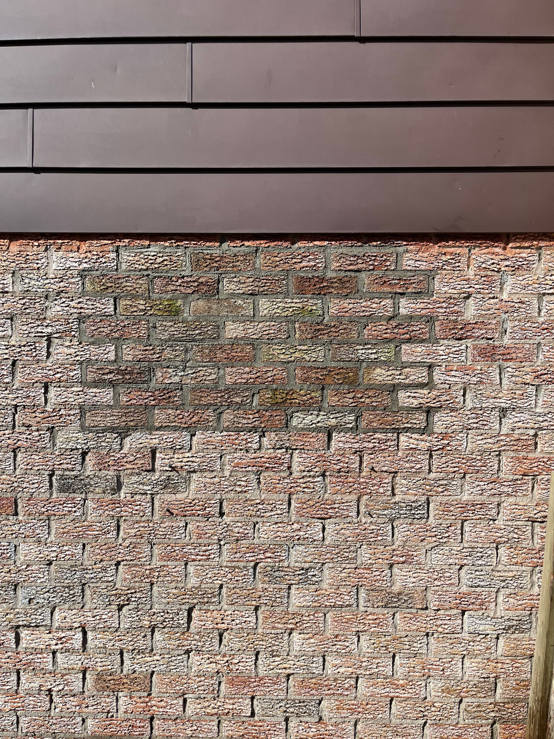 Un gros plan d'un mur de briques avec un tapis dessus.