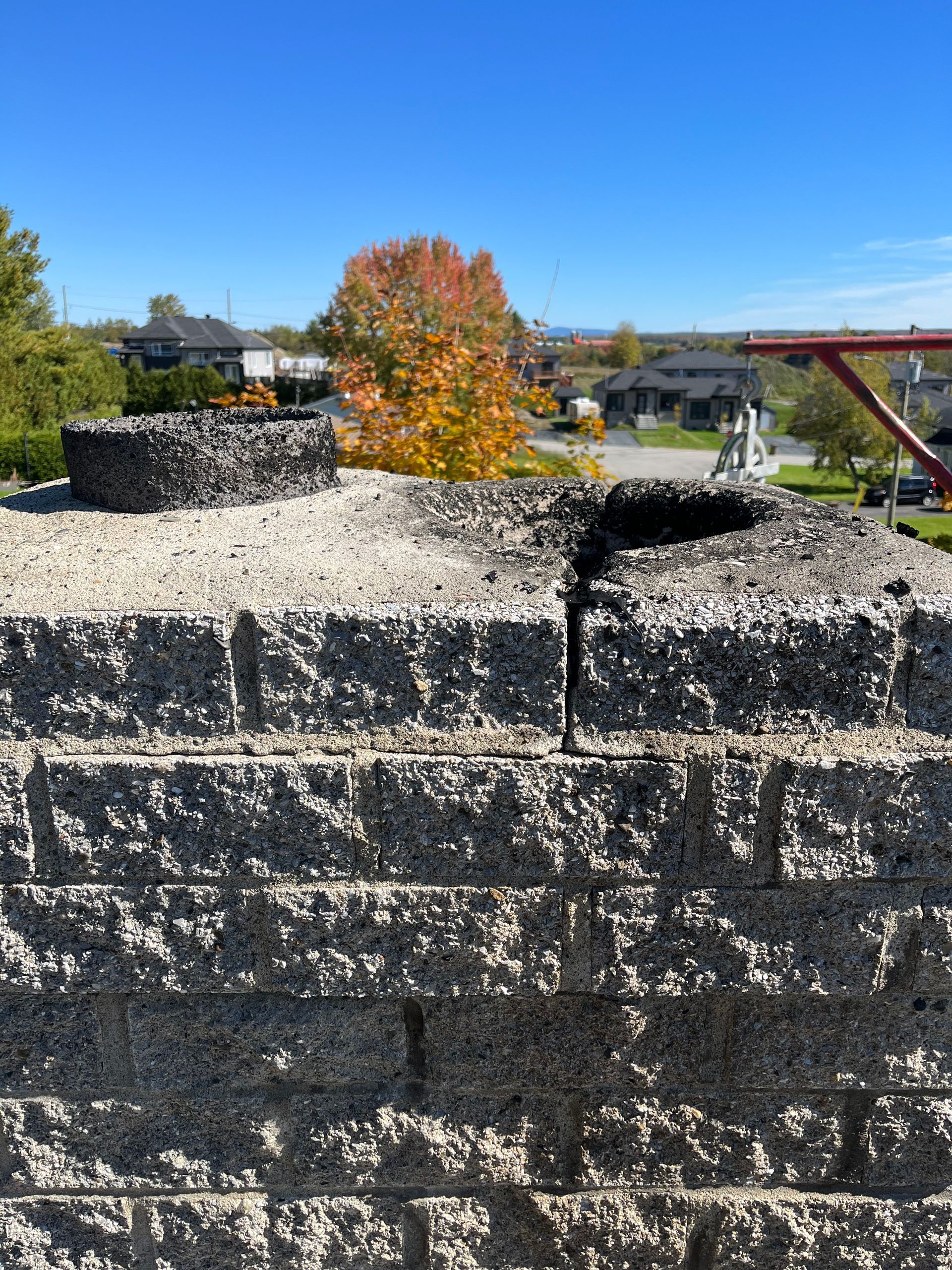 Un mur de briques avec un trou et un pont en arrière-plan.