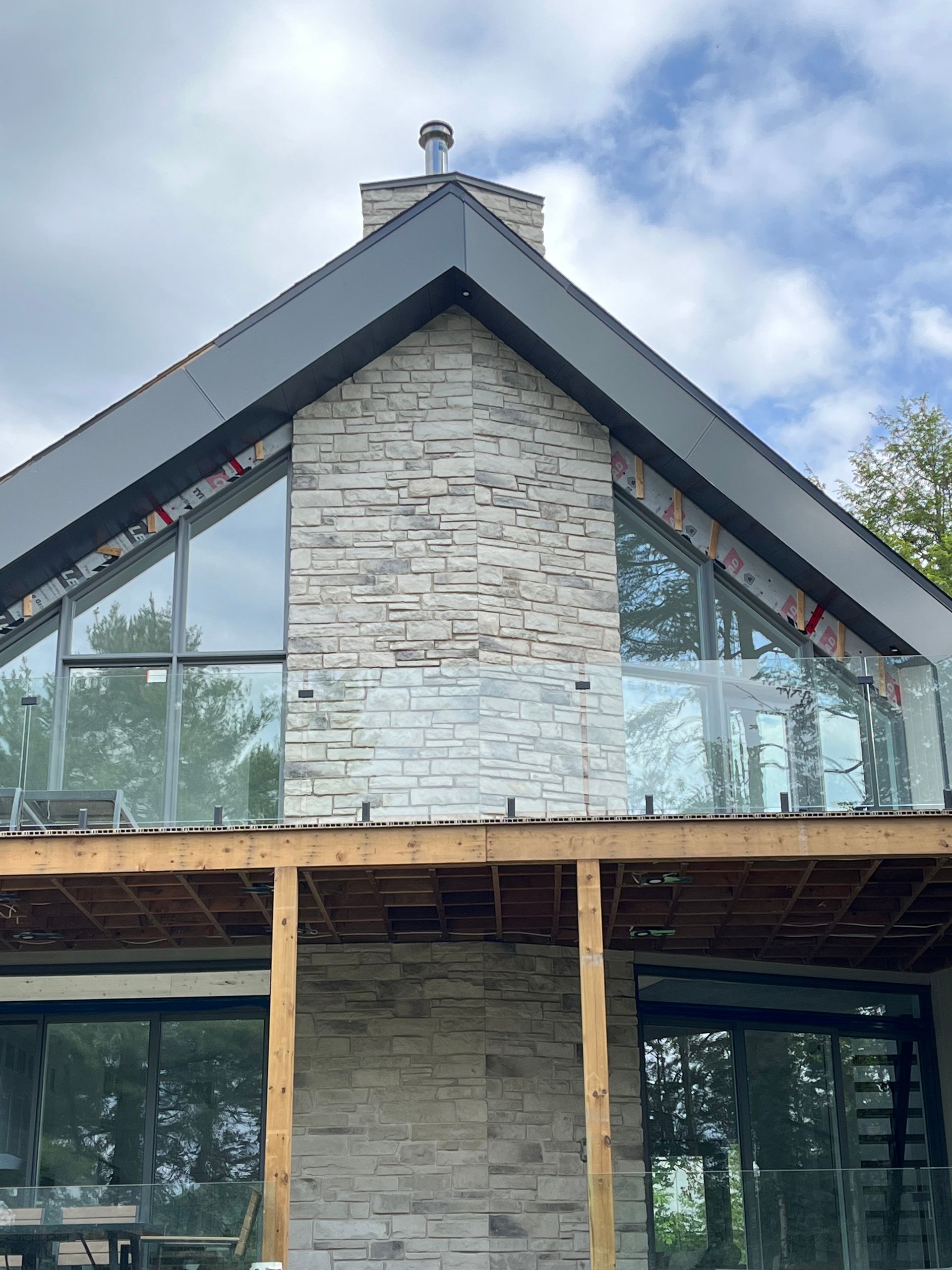 Une maison avec un toit triangulaire et beaucoup de fenêtres