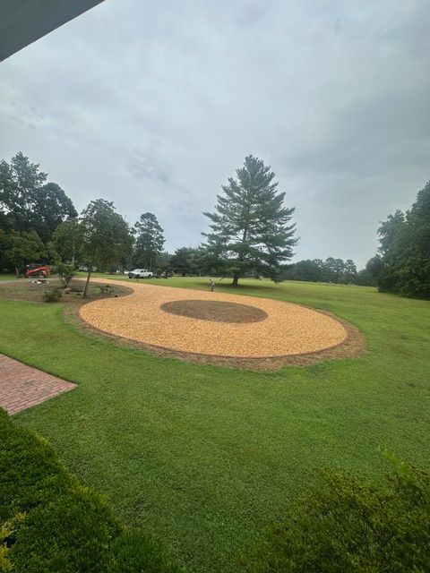 Circular tan gravel seating area in a green park under a cloudy sky