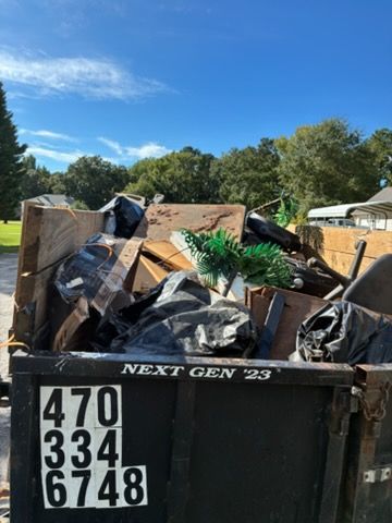 Dumpster full of construction debris and trash outdoors under a blue sky