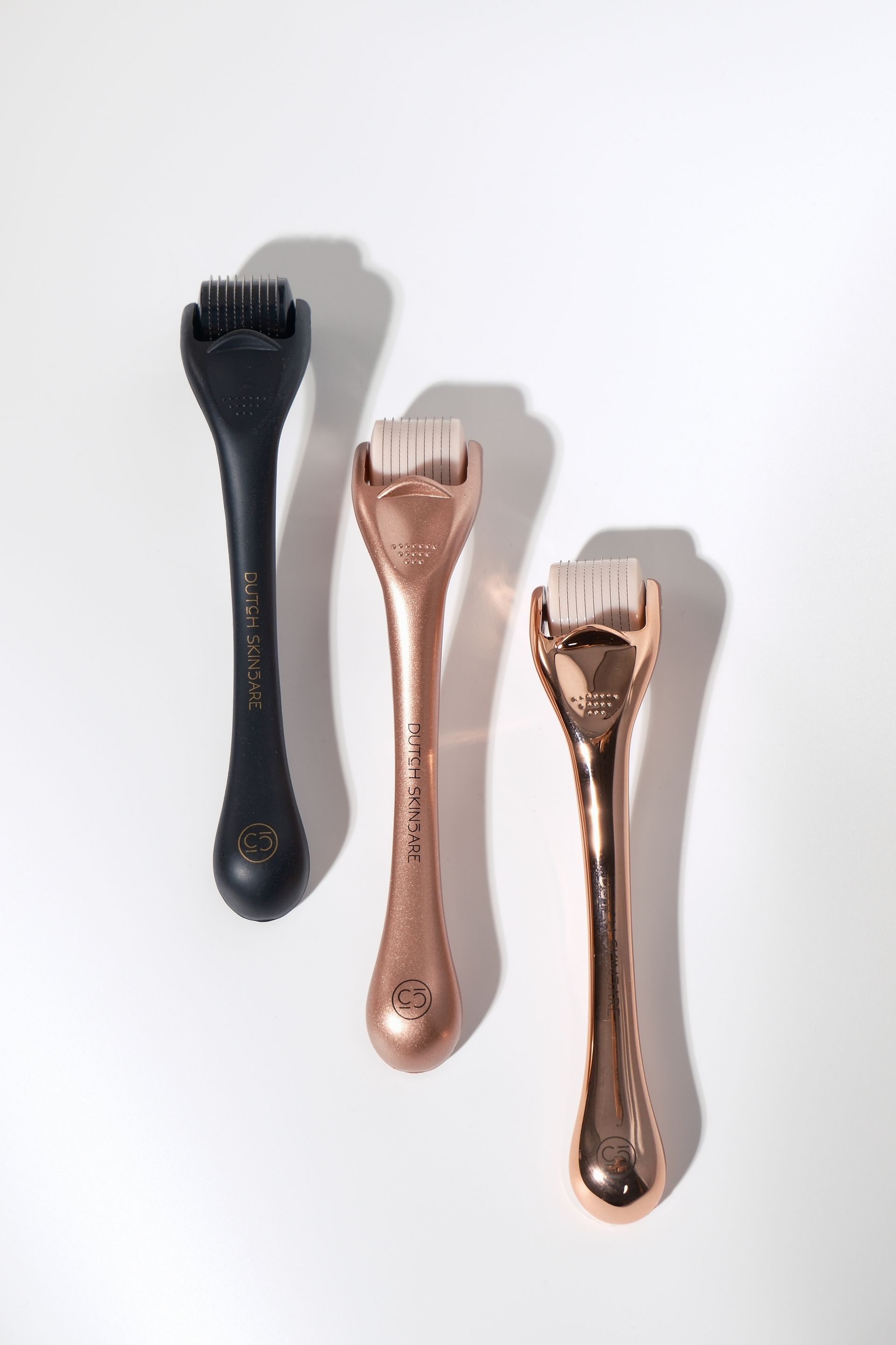 Roségouden en zwarte massageapparaten op een witte achtergrond.