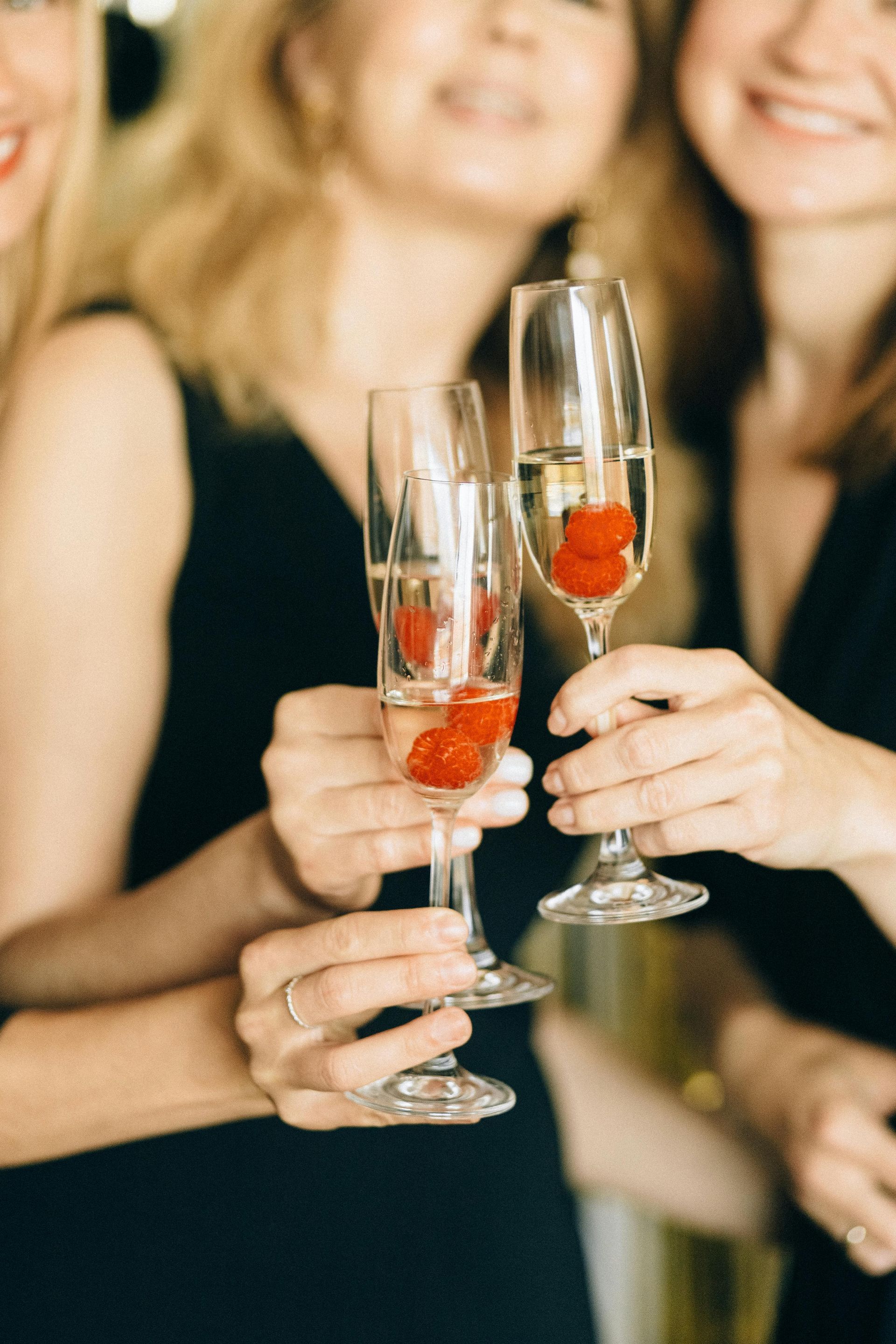 The Harvest Home, Denmead | Three women are holding champagne glasses with strawberries in them.