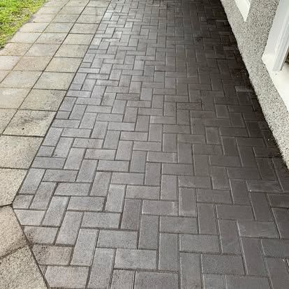Göngustígur úr síldarbeinssteini við hlið rétthyrnds steinsteypts stígs. Dökkgrár múrsteinn, ljósgrár steypa.