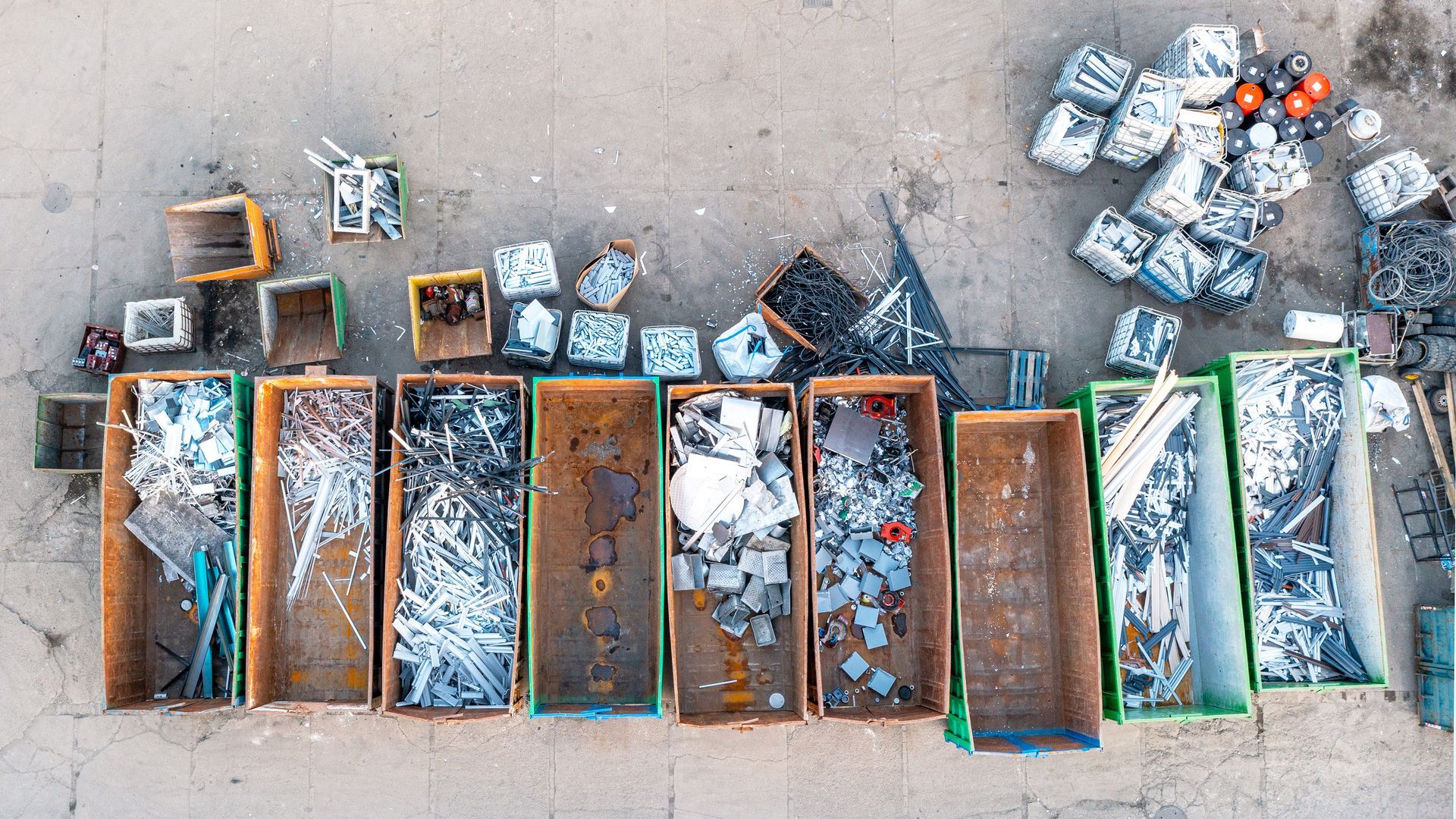 Containers in a scrap yard are filled with scrap metal.