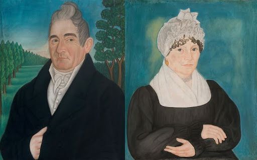 A folk art portrait of a man and woman. Man wears black coat, woman wears dark dress and lace cap.