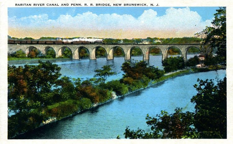Stone bridge with train over Raritan River, New Brunswick, NJ, circa early 1900s.
