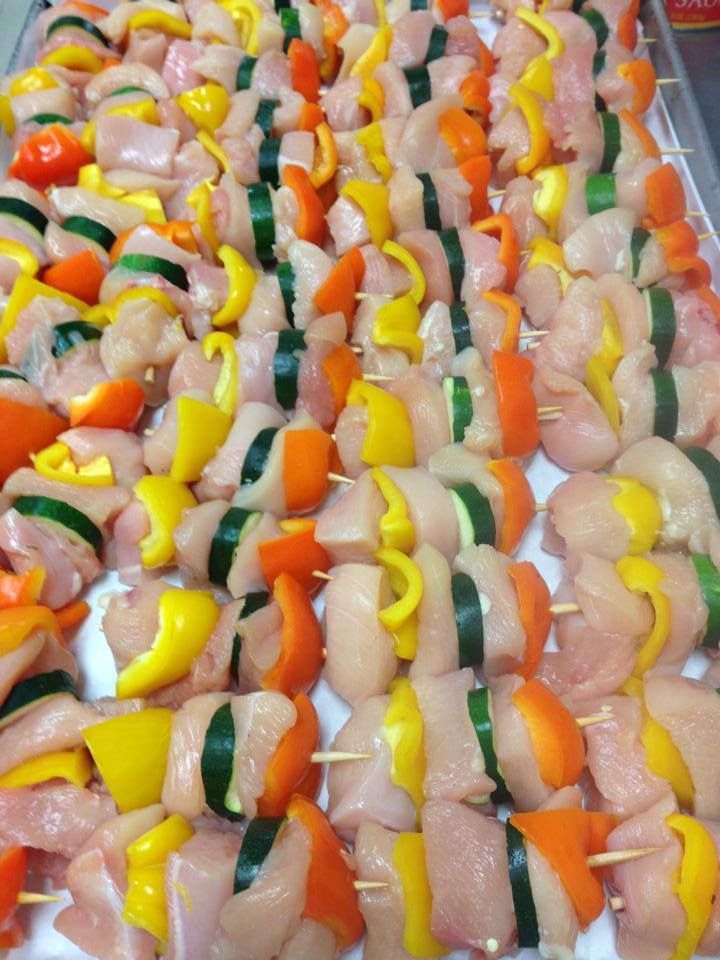 Chicken and vegetable skewers, with yellow, orange, and green peppers on display.