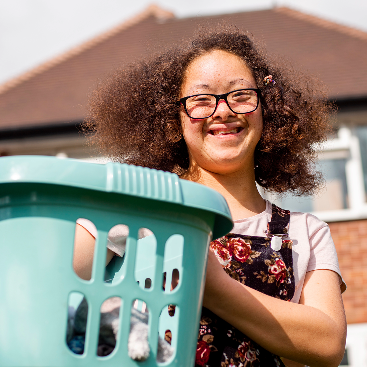 Elleisha's Property Services and Support (EPSS) NDIS participant with a washing basket smiling in Wollongong