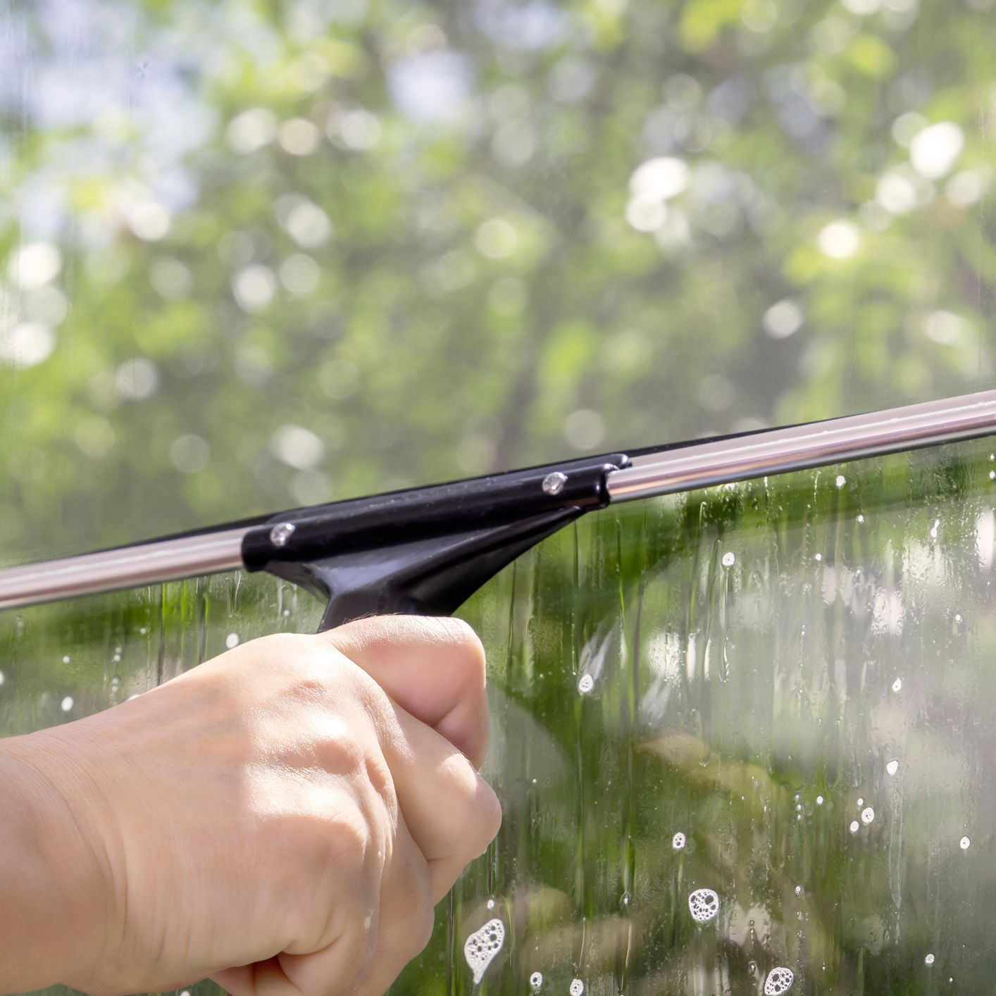 Elleisha's Property Services & Support (EPSS) window cleaner in Wollongong using a squeegee