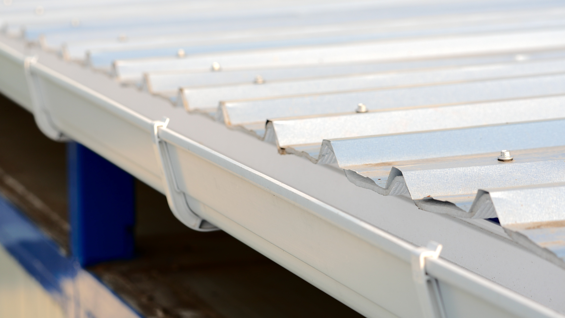 White metal roof with gutter, close-up, bright day.