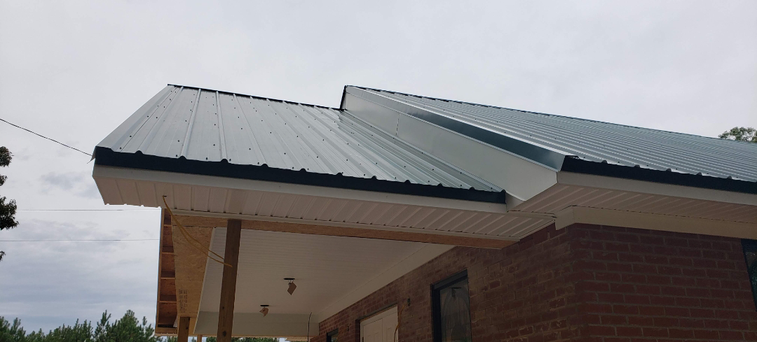 A building with a metal roof against a cloudy sky.