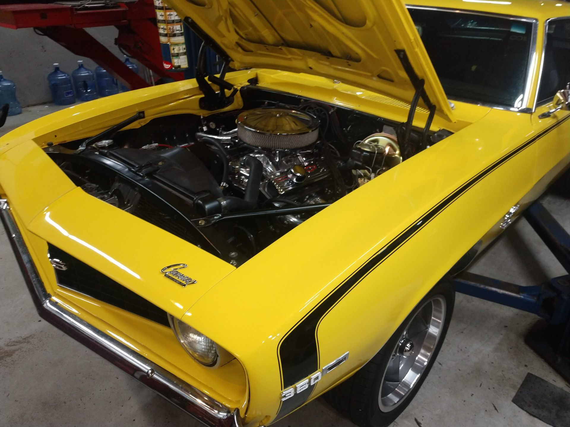 Yellow classic car, hood open, engine visible, black racing stripe. | Autobahn Performance