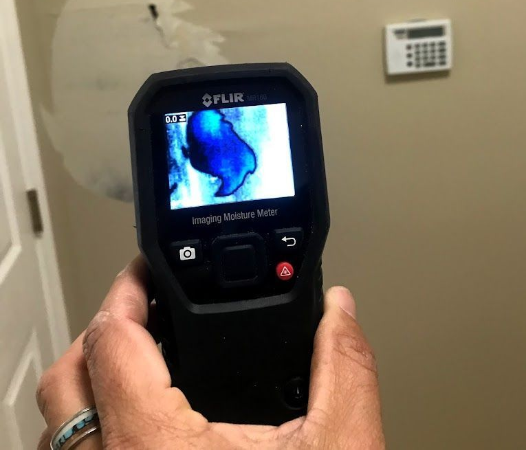 Technician conducting indoor air quality testing with professional sampling equipment