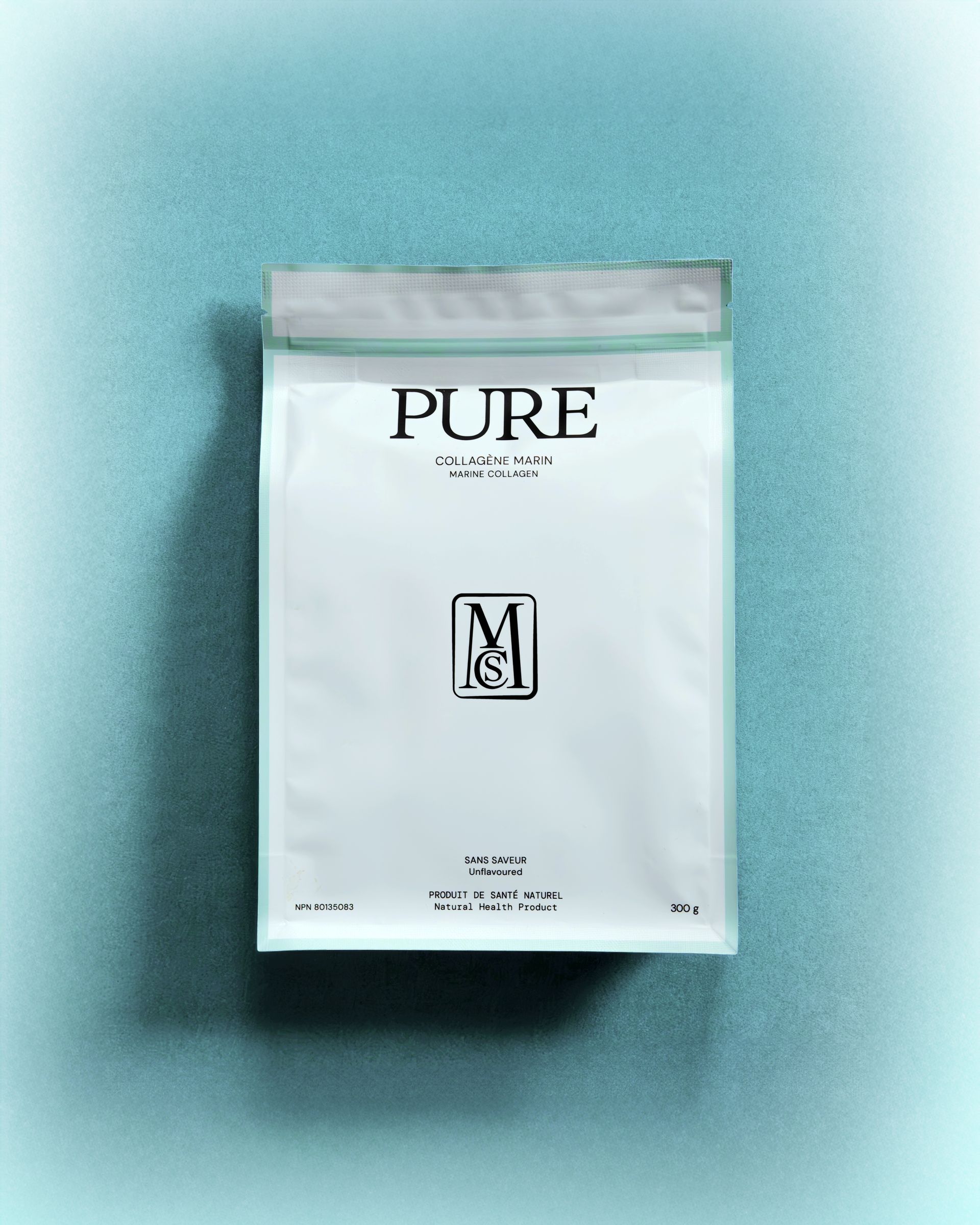 Pochette blanche « PURE » sur fond turquoise, avec une étiquette minimaliste et une ombre en dessous.