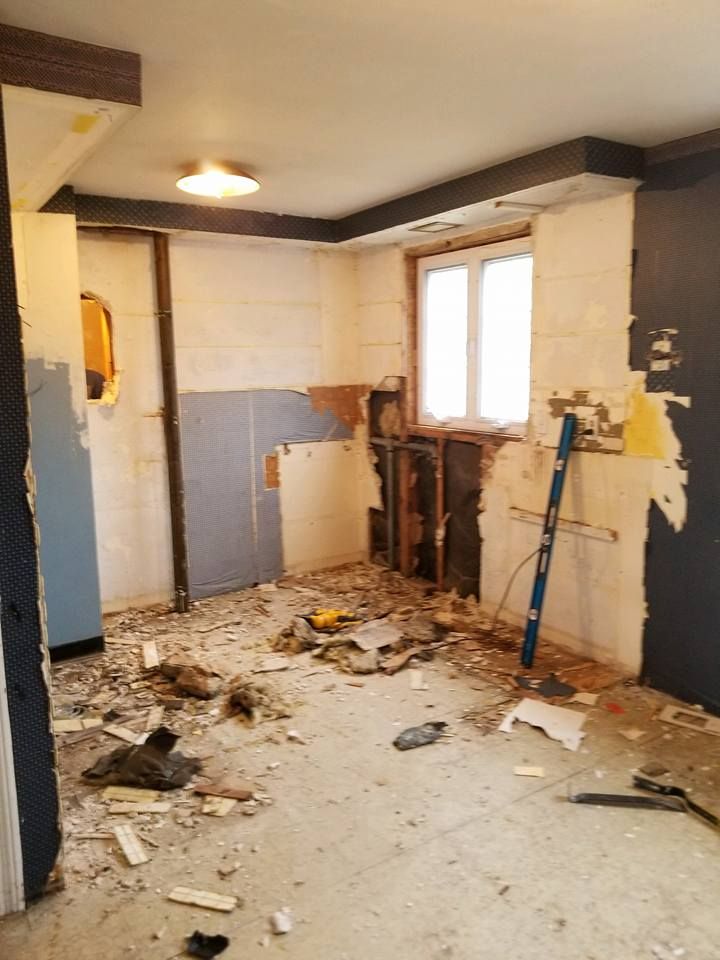 A room that is being remodeled with a lot of trash on the floor.