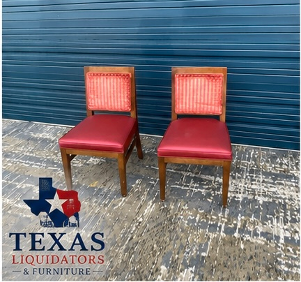 Two red upholstered chairs with wooden legs on a patterned floor against a blue wall