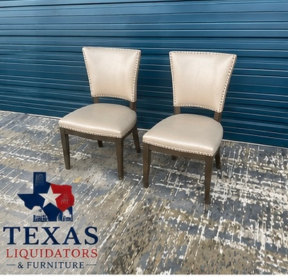 Two cream upholstered chairs on a blue-and-gray patterned floor at Texas Liquidators & Furniture.
