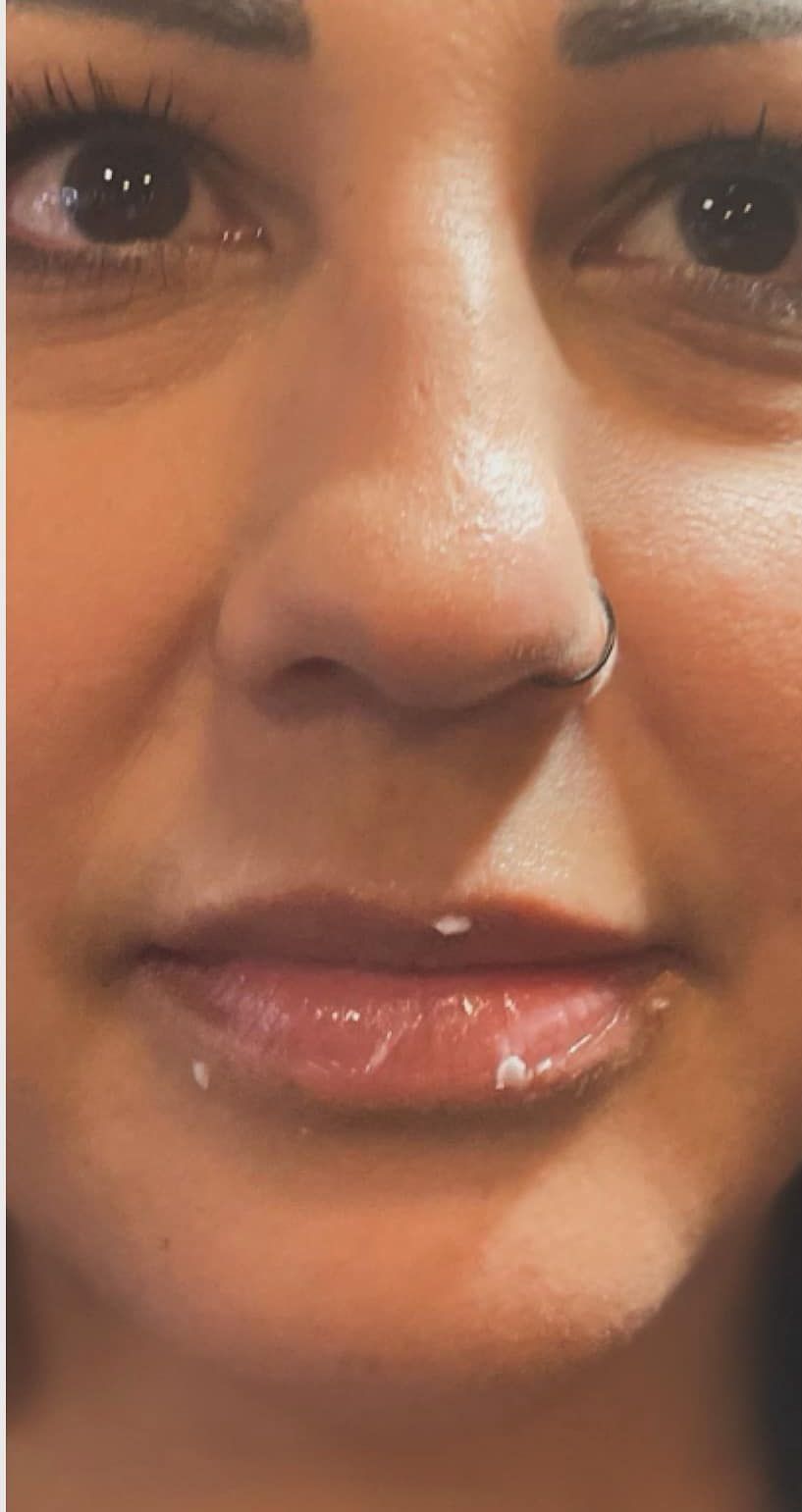 A close up of a woman 's face with a nose ring.
