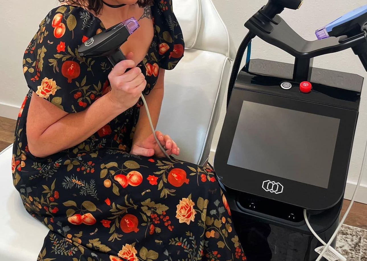 A woman is sitting in a chair holding a hair dryer.