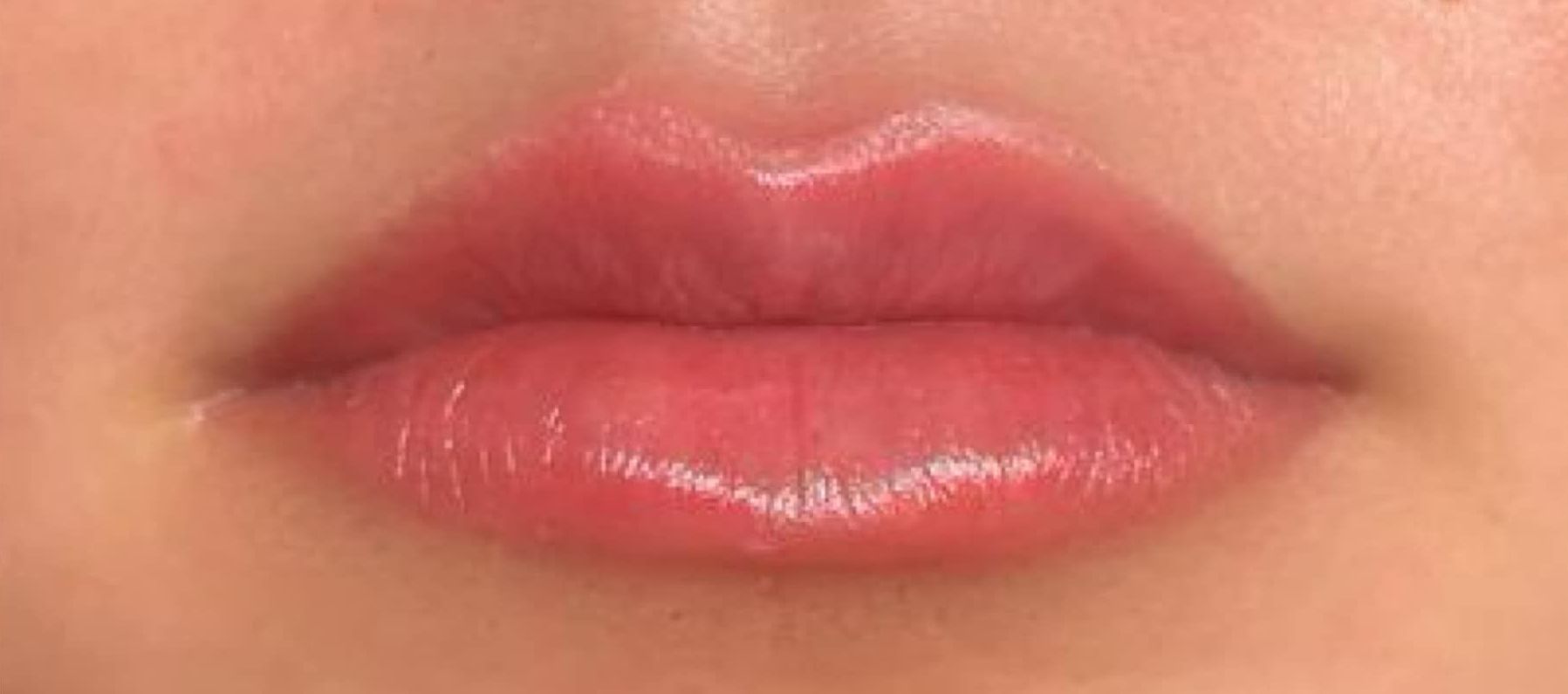 A close up of a woman 's lips with lipstick on them.