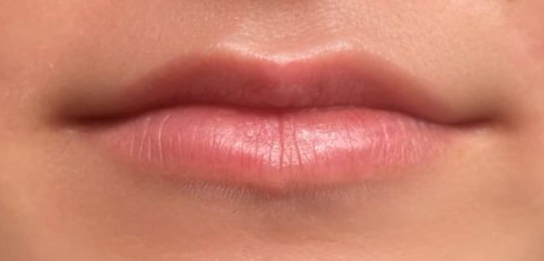 A close up of a woman 's lips with pink lipstick.