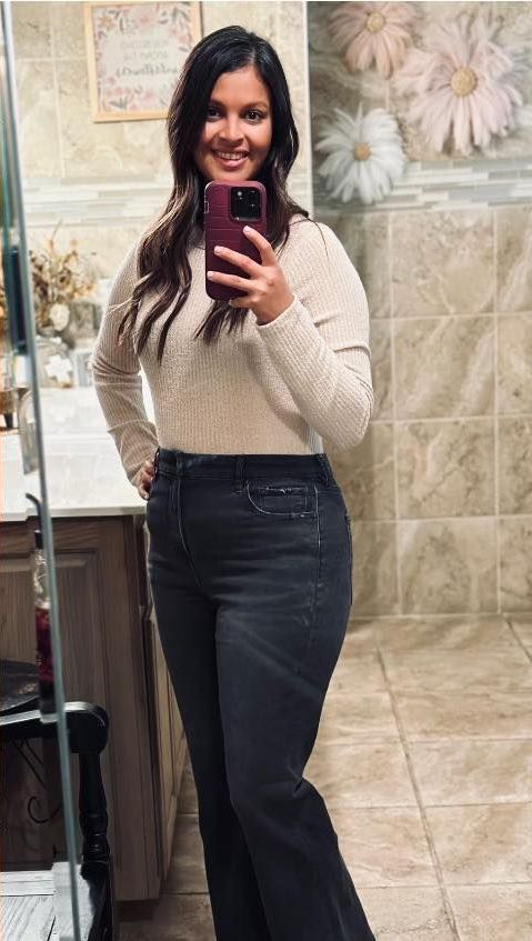 A woman is taking a selfie in a bathroom mirror.