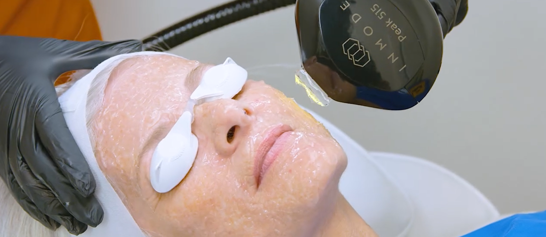 A woman is using a machine to remove hair from a person 's legs.