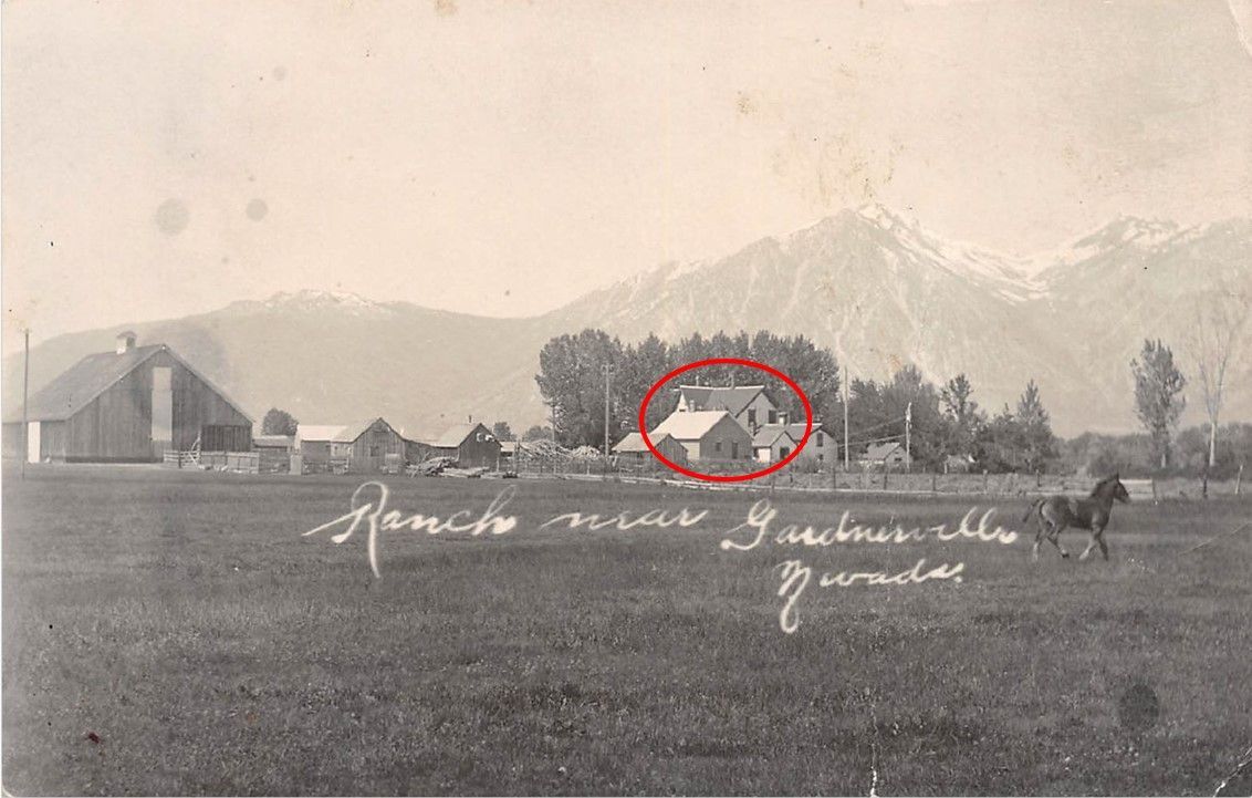 A black and white photo of a farm with mountains in the background and a horse in the foreground.