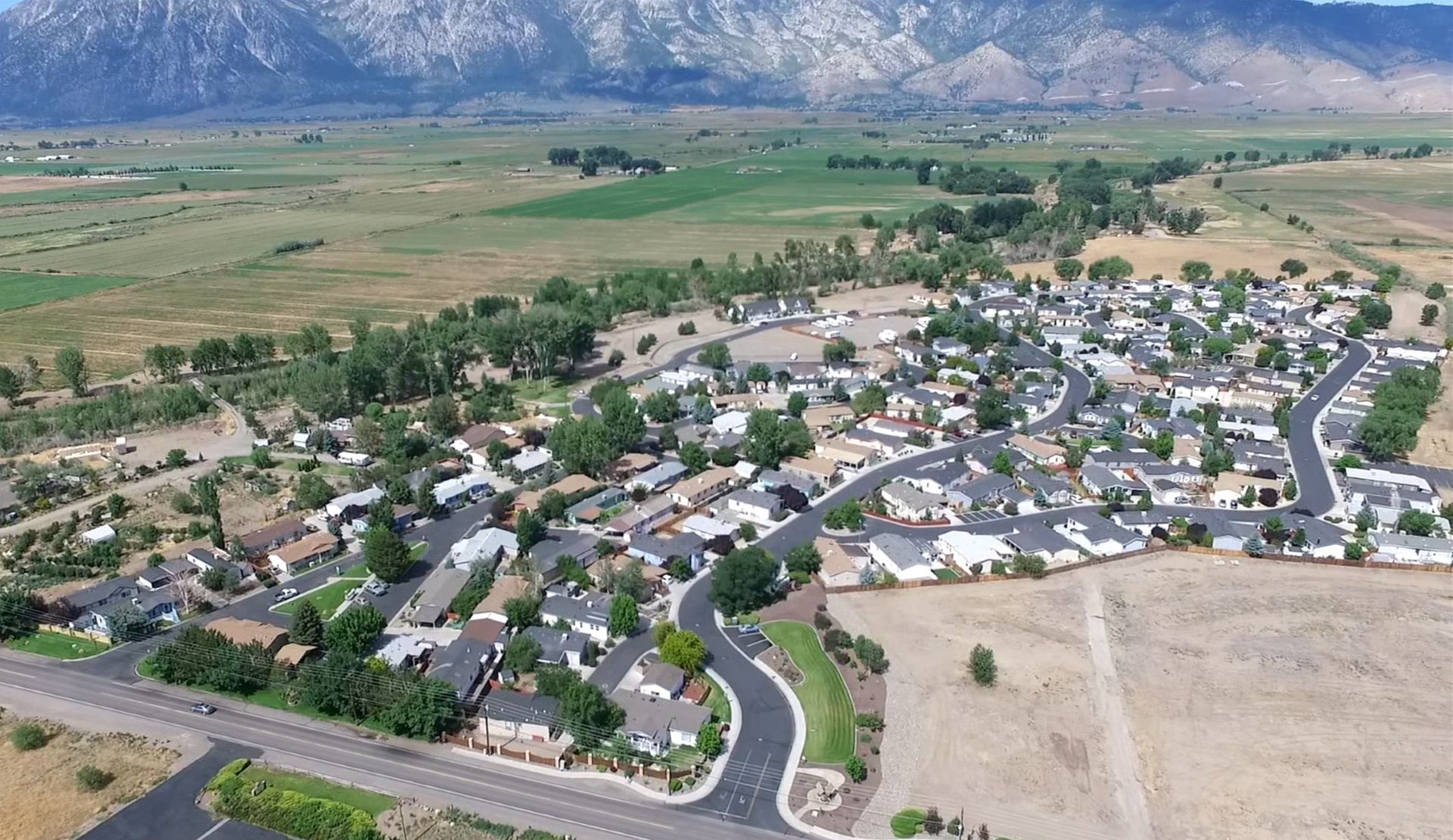 An aerial view of a residential area with mountains in the background