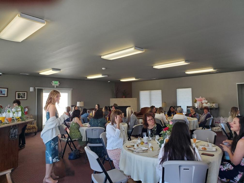 A group of people are sitting at tables in a large room.