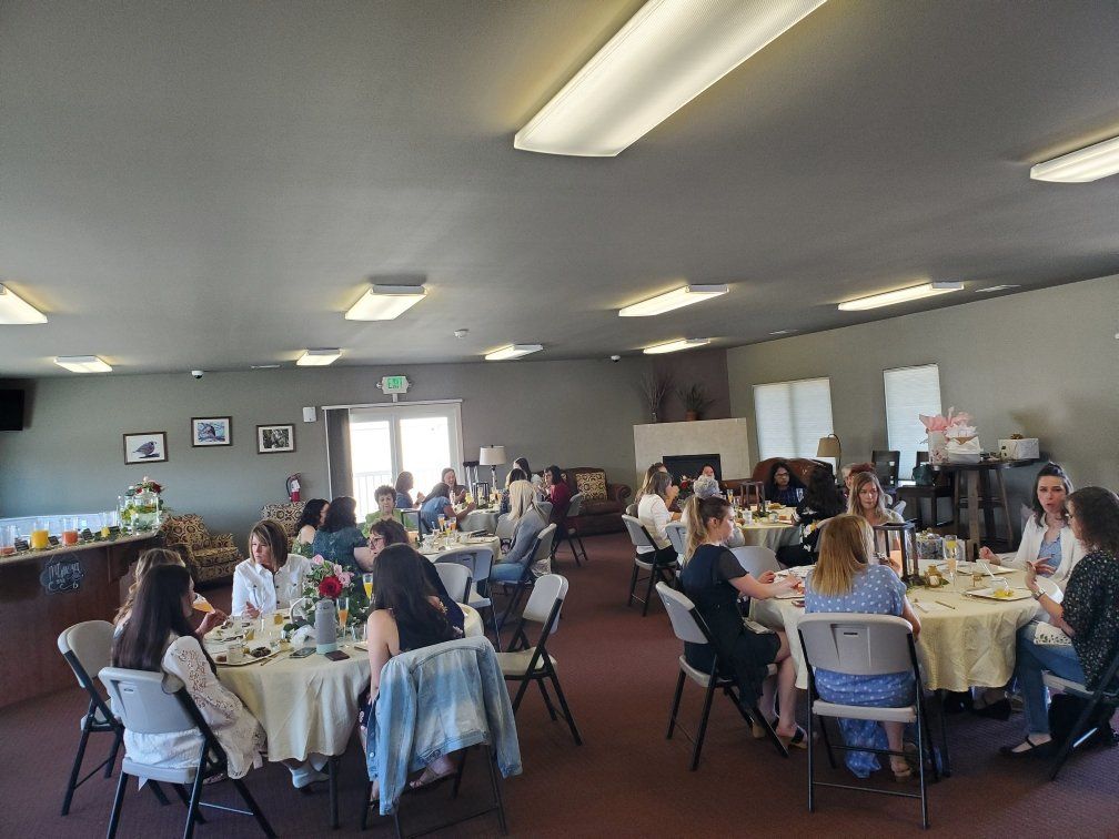 A group of people are sitting at tables in a large room.