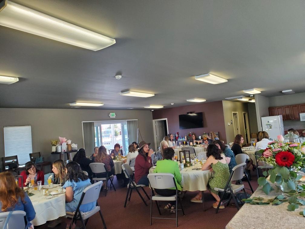 A group of people are sitting at tables in a large room.