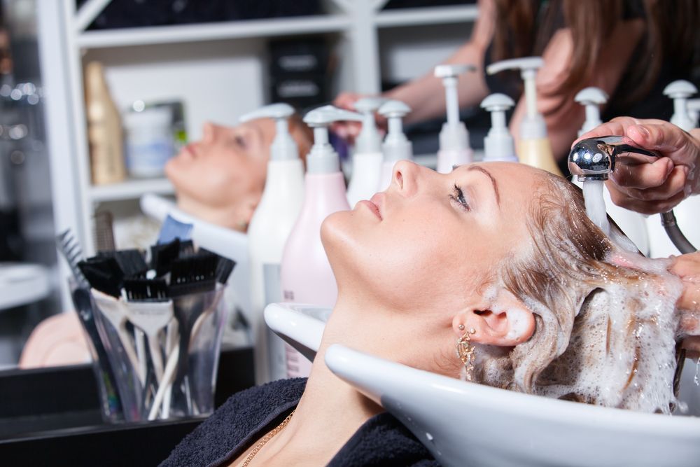A Woman is Getting Her Hair Washed in a Salon — Amore 'D' Hair Studio In Mudjimba, QLD