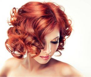 A Woman With Red Curly Hair is Looking Down — Amore 'D' Hair Studio In Mudjimba, QLD