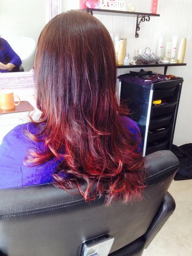 A Woman With Long Red Hair is Sitting in a Chair — Amore 'D' Hair Studio In Mudjimba, QLD