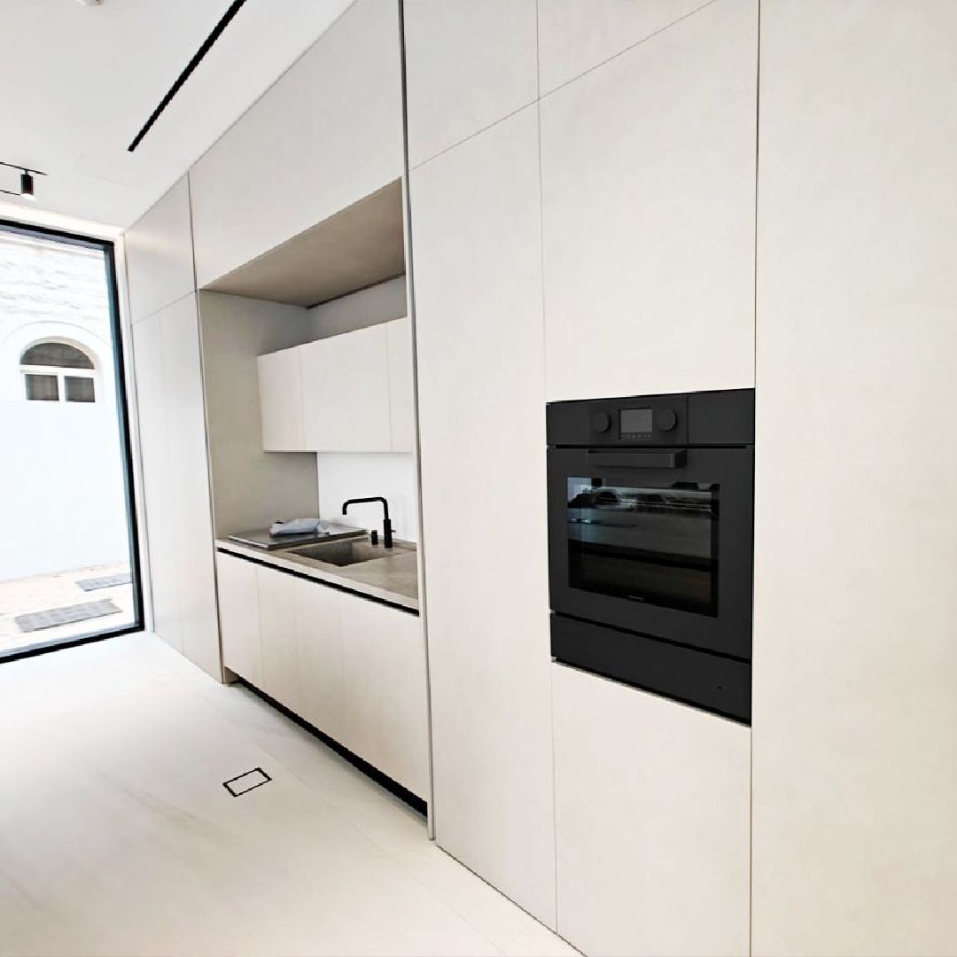 Luxury villa show kitchen Dubai white high-gloss cabinetry and built-in appliances .