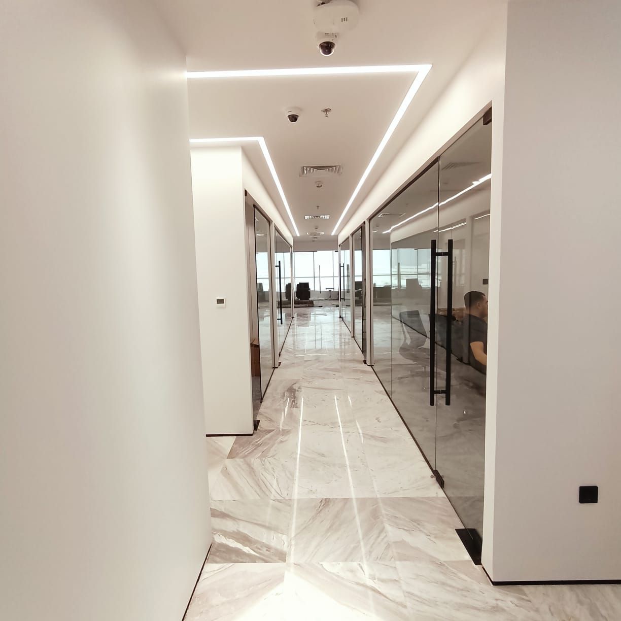 Modern corporate office corridor interior fit-out Dubai glass partitions and lighting