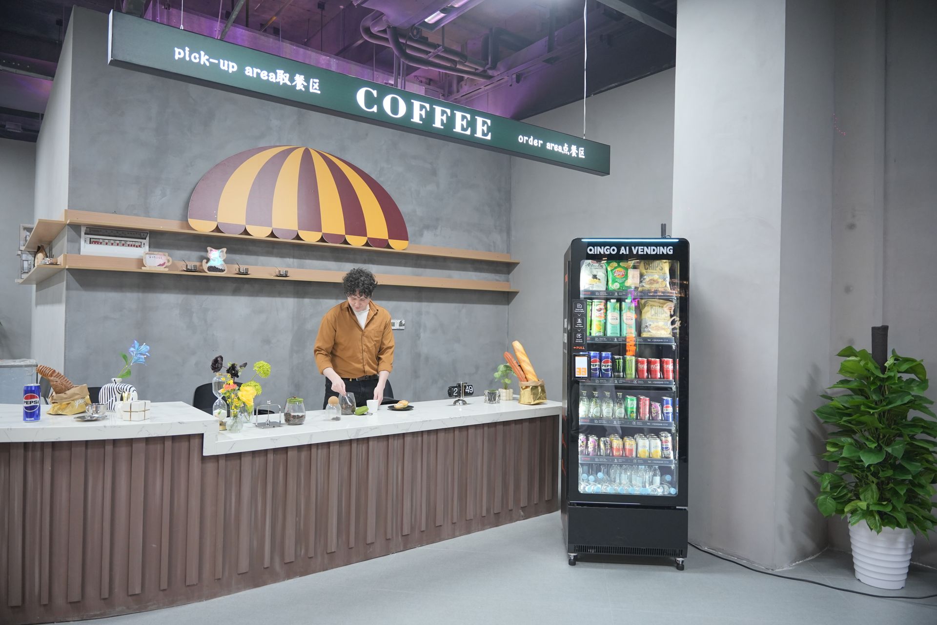 Person using a vending machine in a convenience center; several other machines are visible.