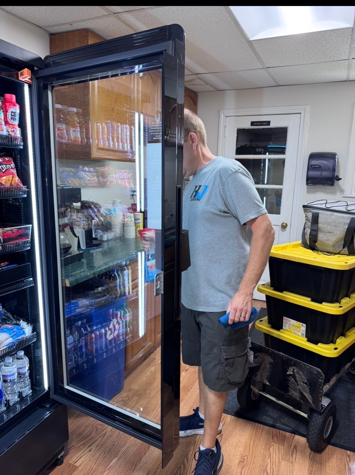 HJ Vending team servicing a smart cooler at a local workplace