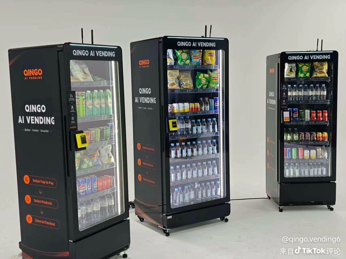 Person using a vending machine in a convenience center; several other machines are visible.