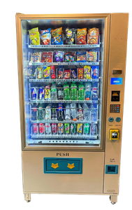 Vending machine stocked with snacks and drinks; beige exterior, glass front.
