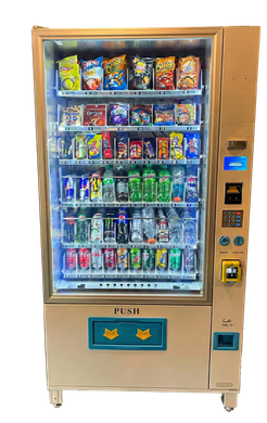 A gold vending machine filled with snacks and drinks, brightly lit, with buttons and a cash slot.