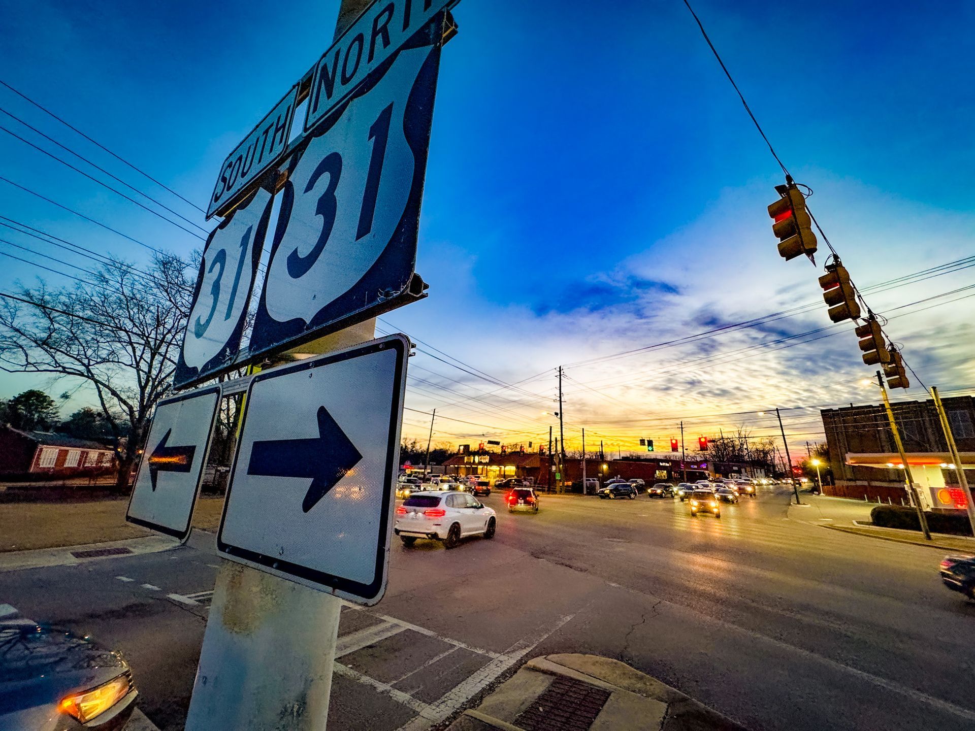A blue and white street sign with an arrow pointing to the right.