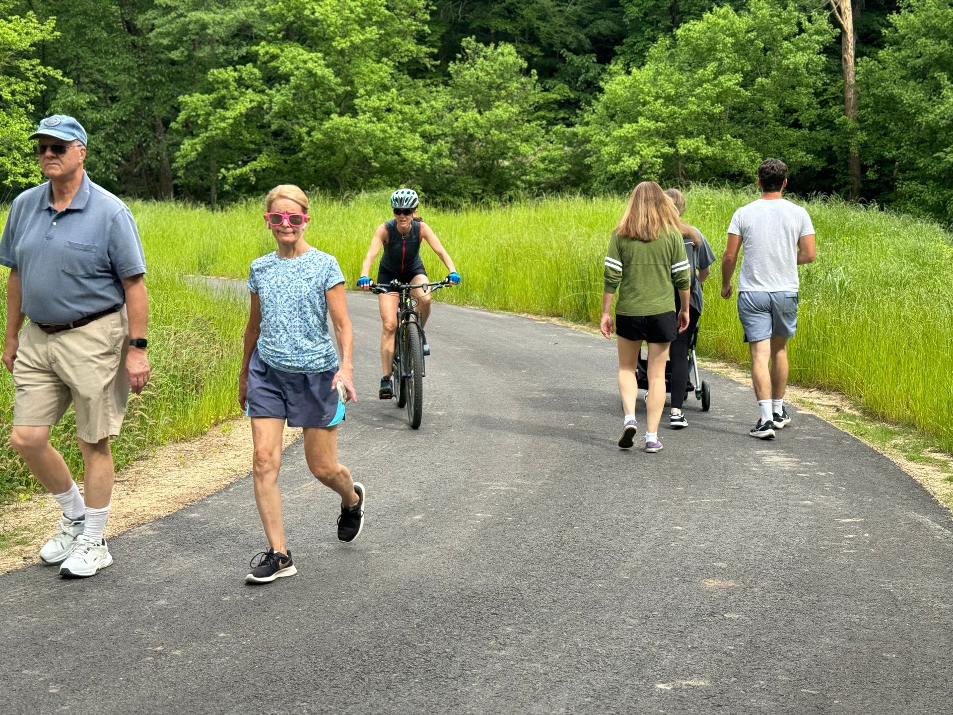 A group of people are walking and riding bikes on a path.