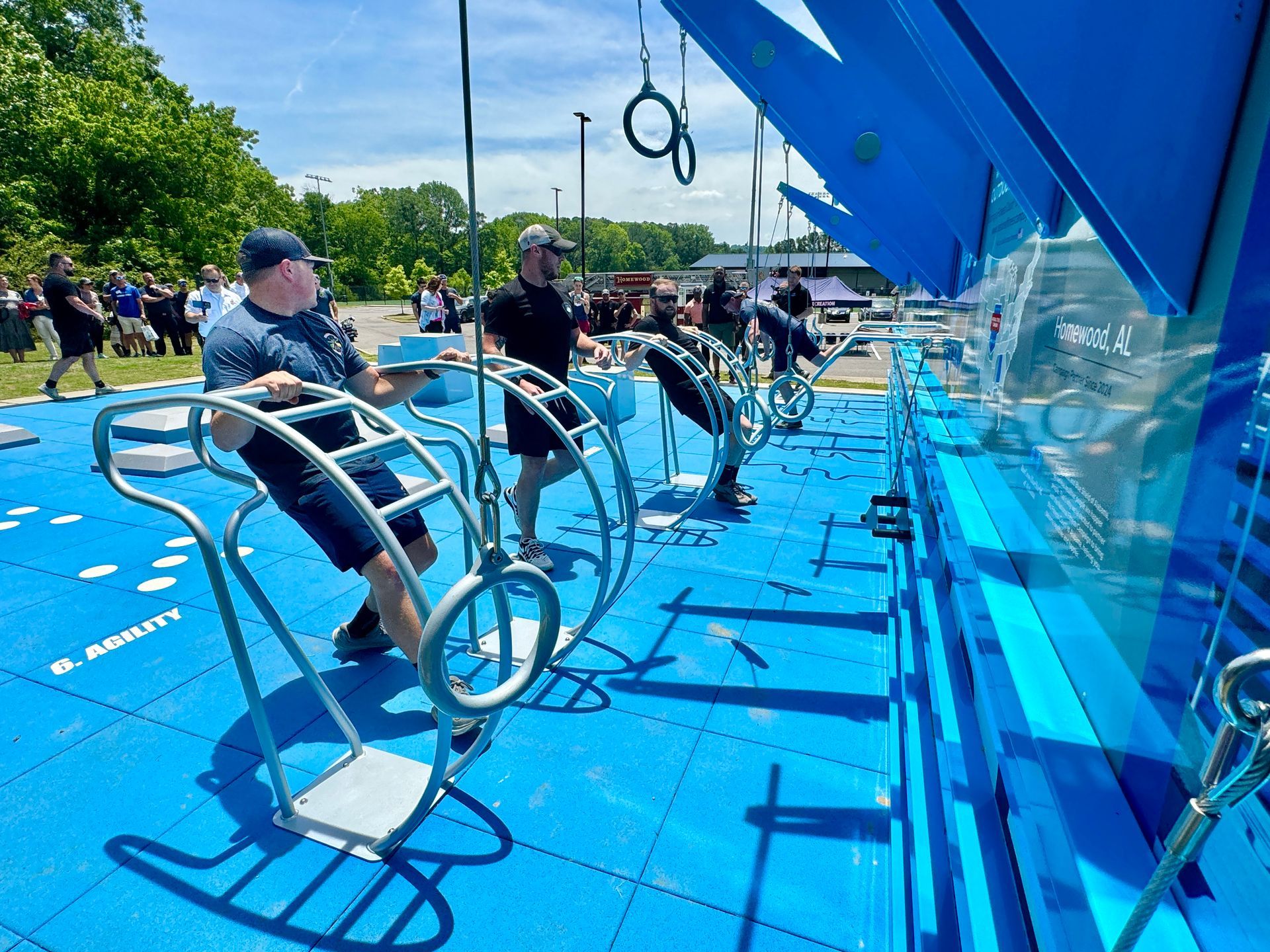A group of men are sitting on exercise equipment in a park.