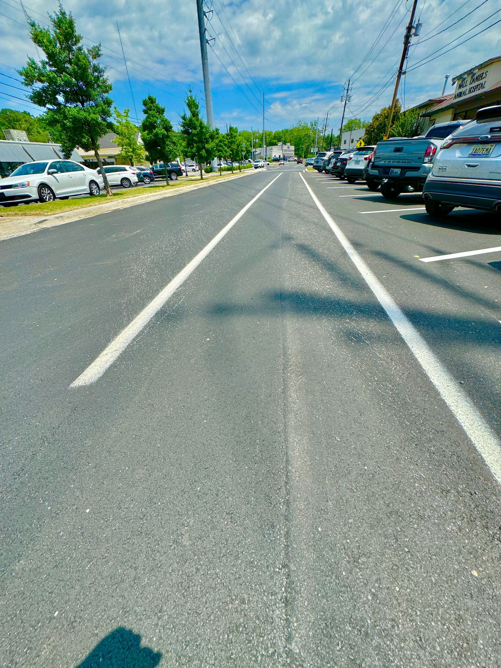 A row of cars are parked on the side of a road.