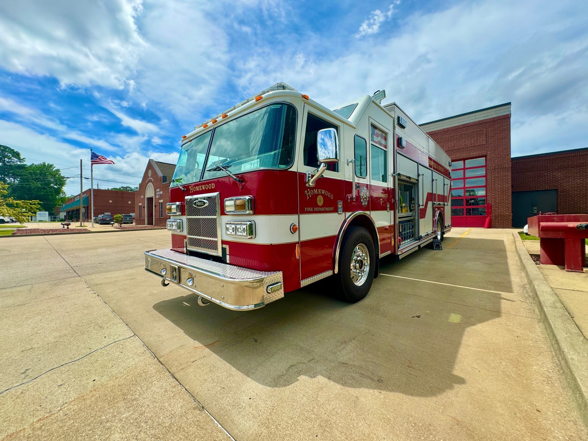 A red and white fire truck is parked in front of a brick building.